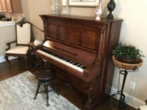 standing piano in a living room.